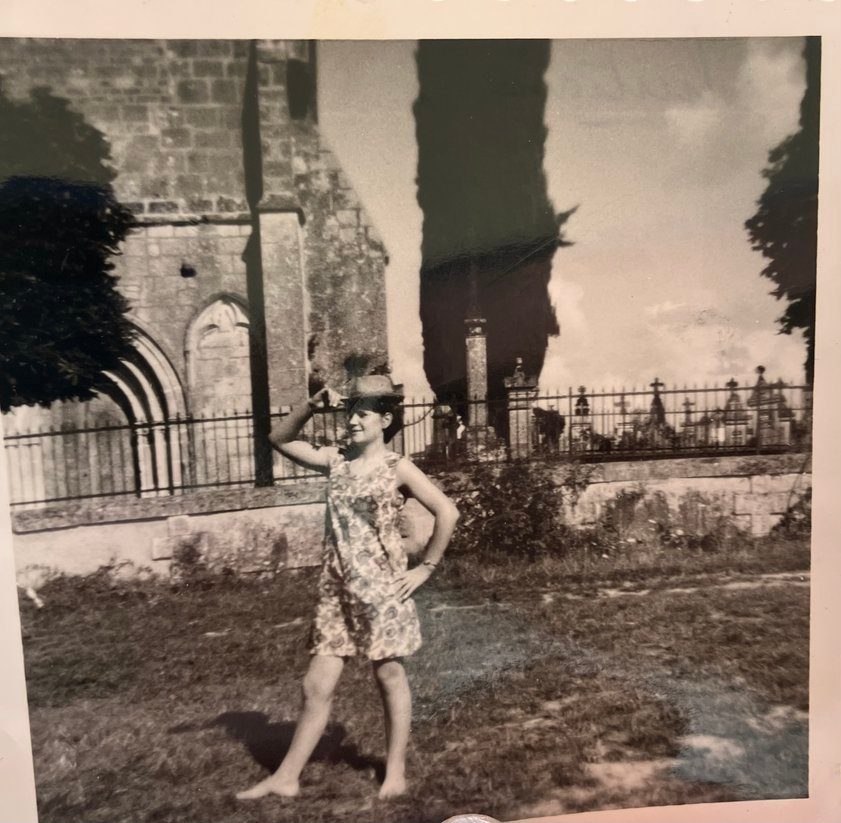 Photographie en noir et blanc d'une jeune fille posant devant l'église de Mérignac